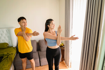 Indonesian southeast asian couple stretching before a workout at home for a healthy lifestyle and body care. Fitness and active lifestyles concept
