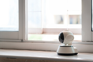 Smart indoor security camera placed on windowsill for home surveillance and remote monitoring technology