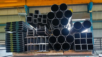 Steel pipes and structural steel shapes secured on a flatbed truck, prepared for delivery to...