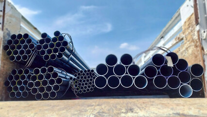 Square steel tubes aligned in a bundle, ready for use in building structures and industrial...