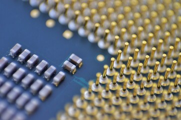 A macro shot of a microchip featuring gold pins and electronic components on a circuit board