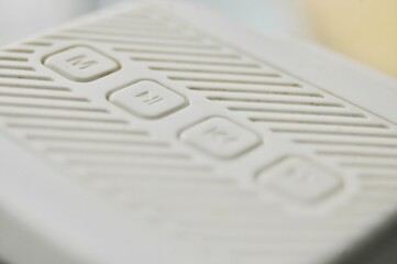 A close-up image of a white control panel with engraved buttons, highlighting the tactile design...