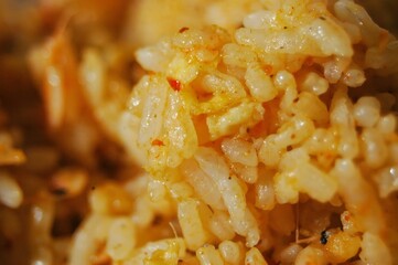 A close-up macro shot of golden, seasoned rice grains with a fluffy texture
