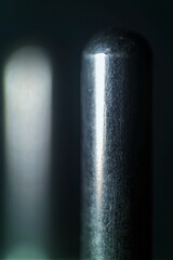 Extreme close-up of a metallic prong from an electrical plug, with visible textures and reflections