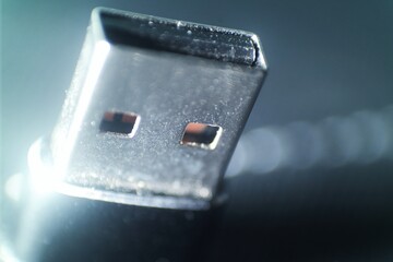 Close-up of a USB plug, focusing on the metallic connector and ports. The shallow depth of field...