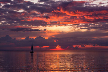 Fototapeta premium Landscape with sailboat on lake at sunset.