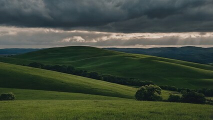 Green hills under a dramatic sky with sun rays breaking through the clouds over the landscape view