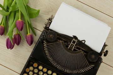 Typewriter and flowers on table