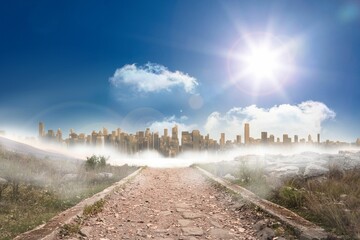 Stony path leading to large urban sprawl under the sun