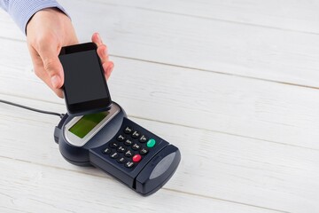 Flat design retail transaction showing tapping smartphone on white counter POS terminal, copy space