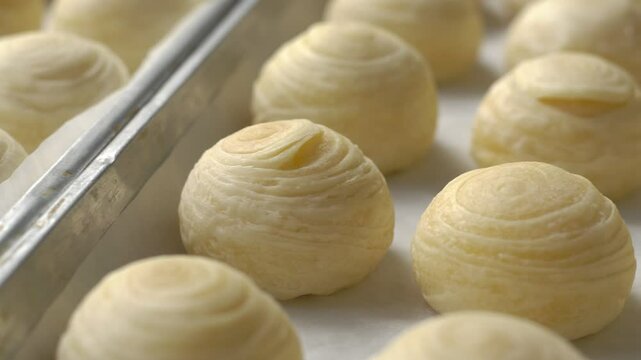 Toasted Mung Bean Cake from the oven. Chinese pastry or moon cake filled with sweet mung bean paste and salted egg yolk. Delicious pastry.