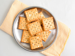 Stack of crunchy chocolate biscuits in squares on a stainless steel plate