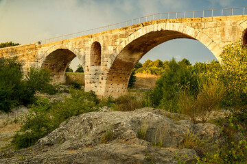 The famous Roman bridge Pont Julien in Bonnieux, Luberon, France. Atmospheric evening scene with a...
