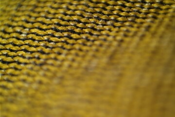 Macro shot of a woven yellow and black textured fabric with a shallow depth of field, creating an...