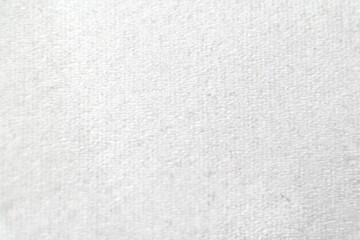 Close-up of a white textured fabric surface, featuring fine, subtle patterns. The image showcases a...