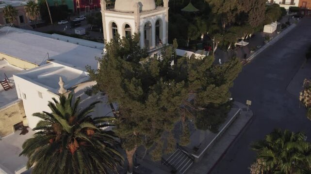 Drone footage at sunrise over Parras de la Fuente, showing urban layout and surrounding terrain under clear sky conditions, captured in stable 4K resolution with smooth tracking and overhead shots.