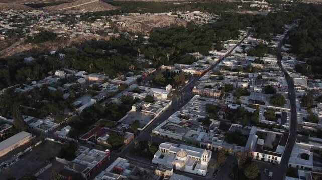 Drone footage at sunrise over Parras de la Fuente, showing urban layout and surrounding terrain under clear sky conditions, captured in stable 4K resolution with smooth tracking and overhead shots.