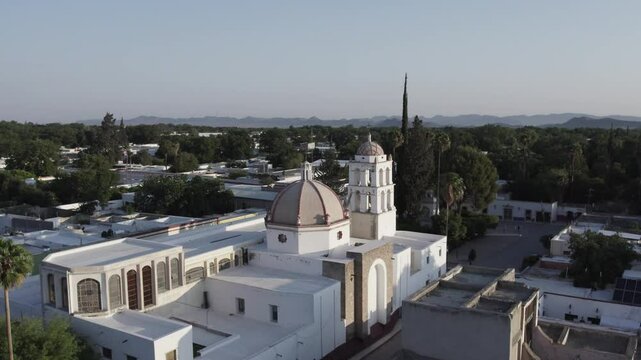 Drone footage at sunrise over Parras de la Fuente, showing urban layout and surrounding terrain under clear sky conditions, captured in stable 4K resolution with smooth tracking and overhead shots.