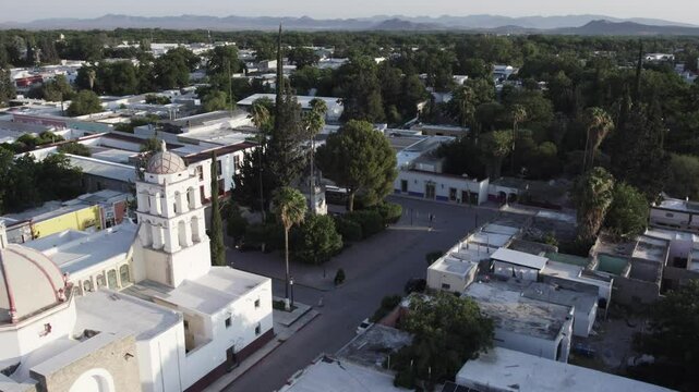 Drone footage at sunrise over Parras de la Fuente, showing urban layout and surrounding terrain under clear sky conditions, captured in stable 4K resolution with smooth tracking and overhead shots.