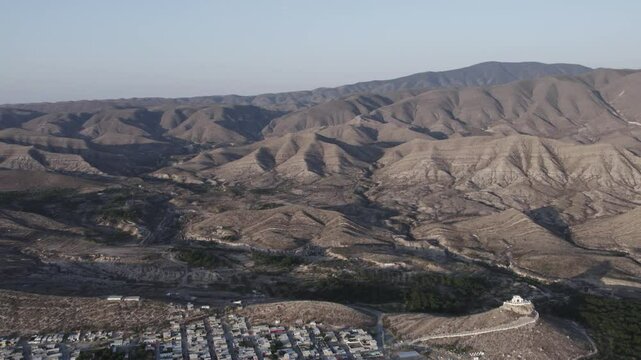 Drone footage at sunrise over Parras de la Fuente, showing urban layout and surrounding terrain under clear sky conditions, captured in stable 4K resolution with smooth tracking and overhead shots.