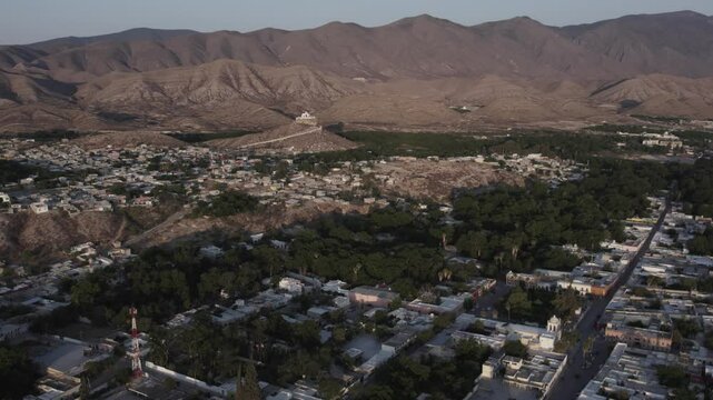 Drone footage at sunrise over Parras de la Fuente, showing urban layout and surrounding terrain under clear sky conditions, captured in stable 4K resolution with smooth tracking and overhead shots.