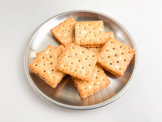 Stack of crunchy chocolate biscuits in squares on a stainless steel plate