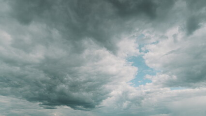 A stunning dramatic cloudscape featuring a vivid blue sky peeking through the clouds Time lapse.