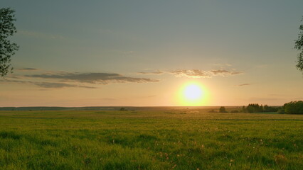 A Beautiful Sunrise Gracefully Spreading Its Warm Golden Light Over Lush and Vibrant Green Fields