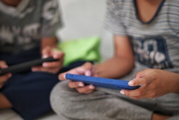 Two Boys Engrossed in Mobile Devices A Study in Modern Childhood and Technology