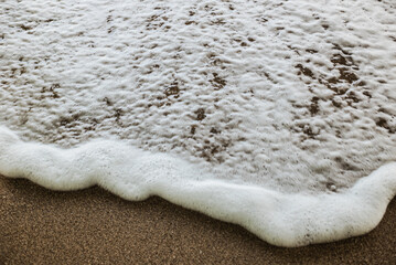 Foam waves on white sand on the beach