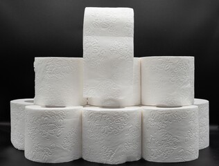 Stack of White Toilet Paper Rolls on Dark Surface – Clean and Minimal Style. Hygiene and Supply...