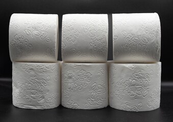 Stack of White Toilet Paper Rolls on Dark Surface – Clean and Minimal Style. Hygiene and Supply...