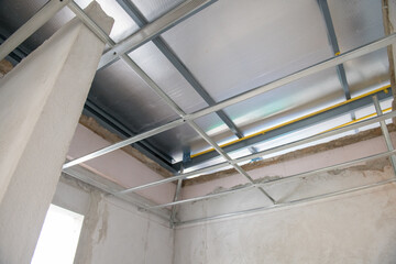 Obraz premium Interior renovation project showing aluminium ceiling framework and electrical wiring installation. new construction progress shows modern ceiling and room design
