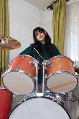 teenage girl playing drums at home