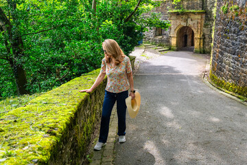 Female tourist walking up to the top of Mount Urgull and enjoying the mossy path, San Sebastian