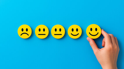 Yellow expressive emoji icons on blue background showing various moods, with one selected smiling face, representing emotional choice, positive reaction, and human expression