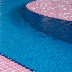 Obraz premium swimming pool in the hotel. blue swimming pool. Blue pool water texture with pink tiles.