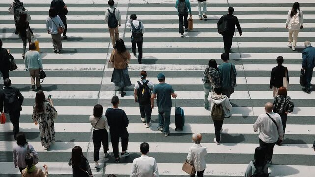 Aerial view of pedestrians walk crossing road intersection junction in downtown. Osaka, Japan.