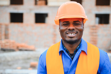 African american construction worker. Portrait of mason bricklayer installing red brick with trowel...