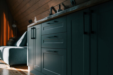 Minimalist wooden cabin kitchen interior with modern matte cabinets, natural wood countertop, soft...