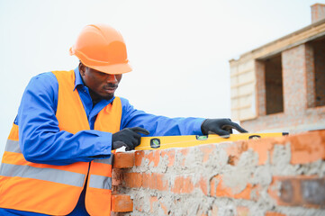 Construction african american worker in uniform and safety equipment have job on building.