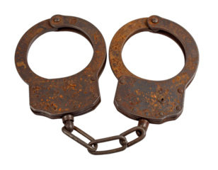 A pair of antique, heavily rusted metal handcuffs, symbolizing law enforcement, detention, security, and a sense of history or restriction.