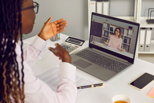 African American woman financial accountant, business advisor, online school headmaster or professional hiring manager discusses salary with math teacher via video call on laptop notebook computer