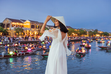 Chic Woman in White Dress Admiring Lantern Boats at Hoi An River Festival