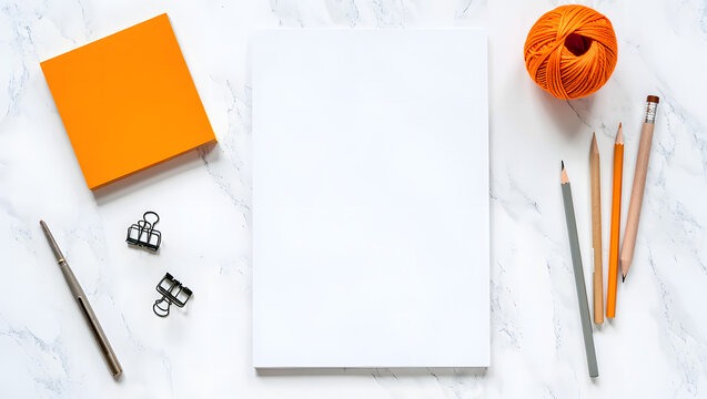 Creative workspace flat lay with blank paper pencils orange sticky notes and yarn