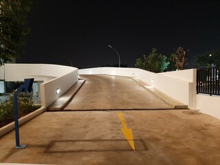 Nighttime Parking Ramp Entrance with Yellow Arrow and Lights.