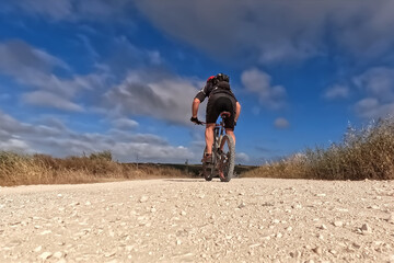 Cyclist Riding the Bike on the Dirt Road