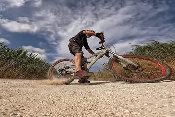 Cyclist Riding a Mountain Bike on Dirt Road.