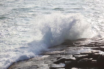 The ocean is rough and the waves are crashing against the rocks