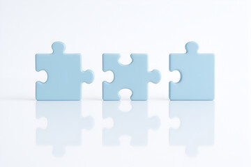 Three puzzle pieces on a white surface, teamwork concept